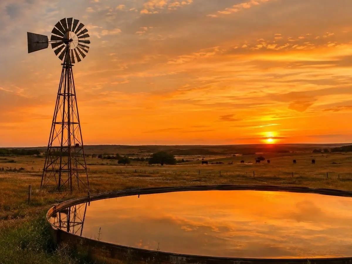 Windmill and stock tank at sunset Windmill and stock tank at sunset